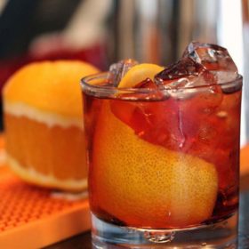 Side view Americano cocktail with orange and ice