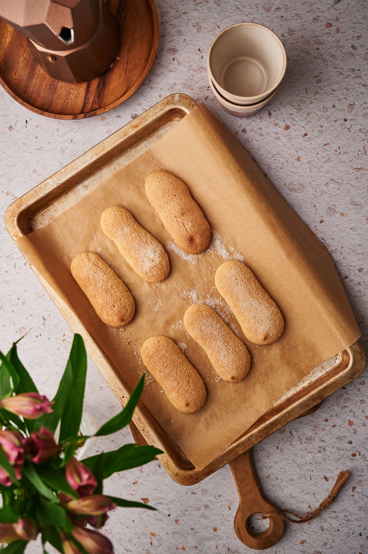 picture of homemade ladyfingers on a baking sheet right out of the oven