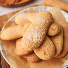 picture of homemade ladyfingers savoiardi cookies on a plate next to a coffee moka maker