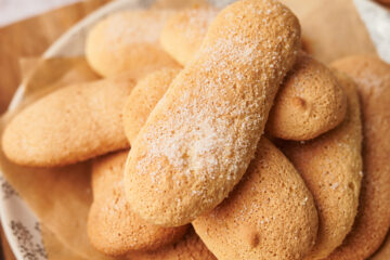 picture of homemade ladyfingers savoiardi cookies on a plate next to a coffee moka maker