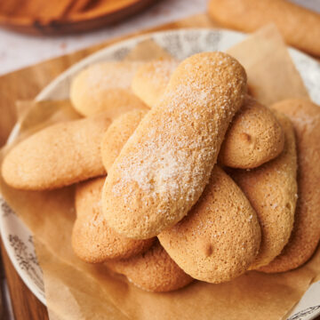 picture of homemade ladyfingers savoiardi cookies on a plate next to a coffee moka maker