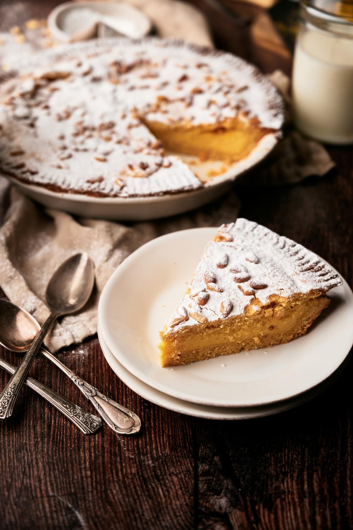picture of a slice of torta della nonna on a small plate on a table