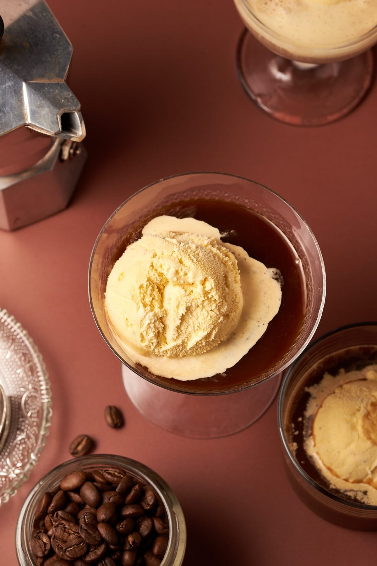 picture of affogato next to coffee beans and coffe maker