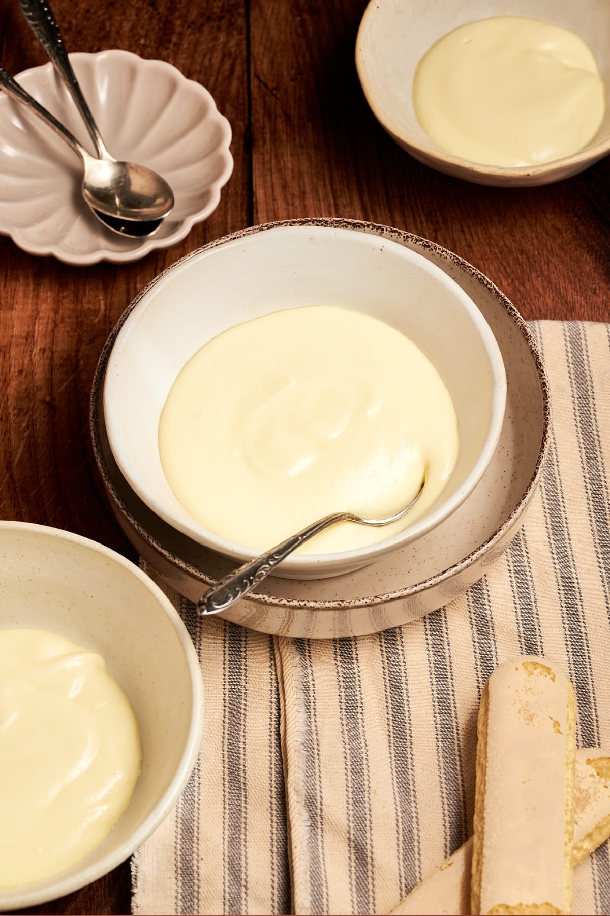 finished italian mascarpone cream served in a bowl next to savoiardi cookies
