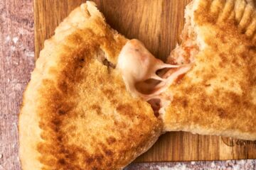 Panzerotti cut in half on a cutting board.