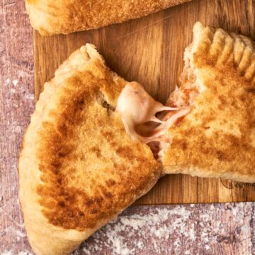 Panzerotti cut in half on a cutting board.