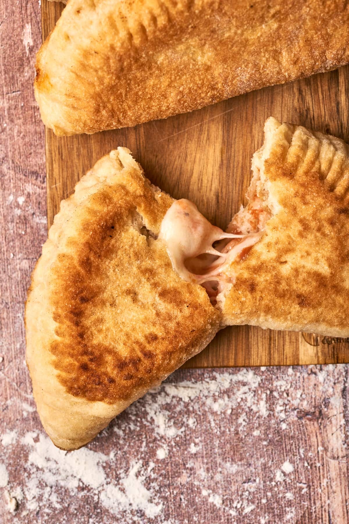 Panzerotti cut in half on a cutting board.