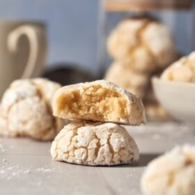 two italian almond cookies on top of each other. the one on top has a bite.