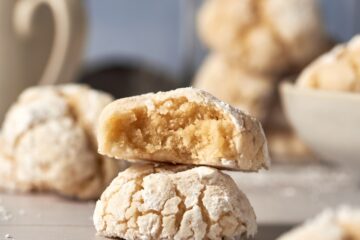 two italian almond cookies on top of each other. the one on top has a bite.