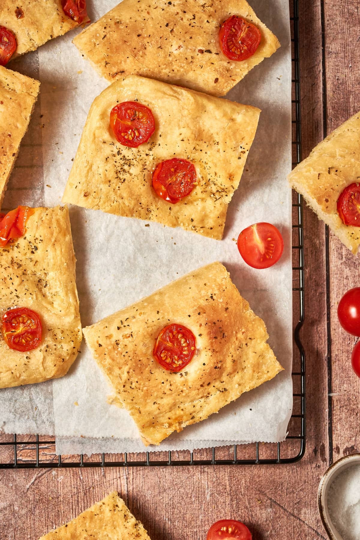 sliced tomato focaccia on a sheet pan with parchment paper