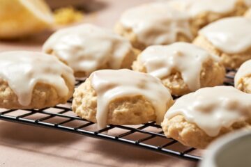 Frosted ricotta cookies on a wire rack.