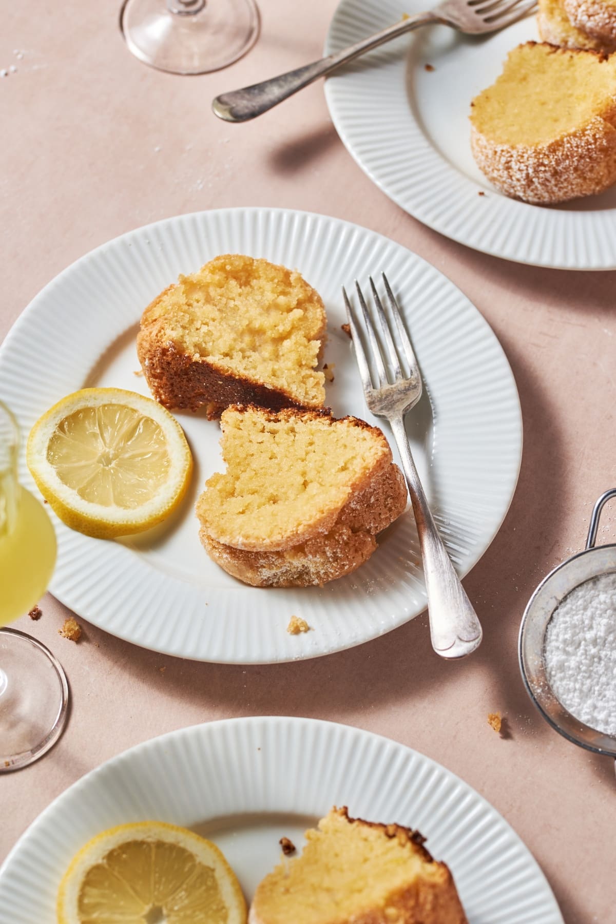 slices of limoncello cake on a white plate with a slice of lemon and a fork